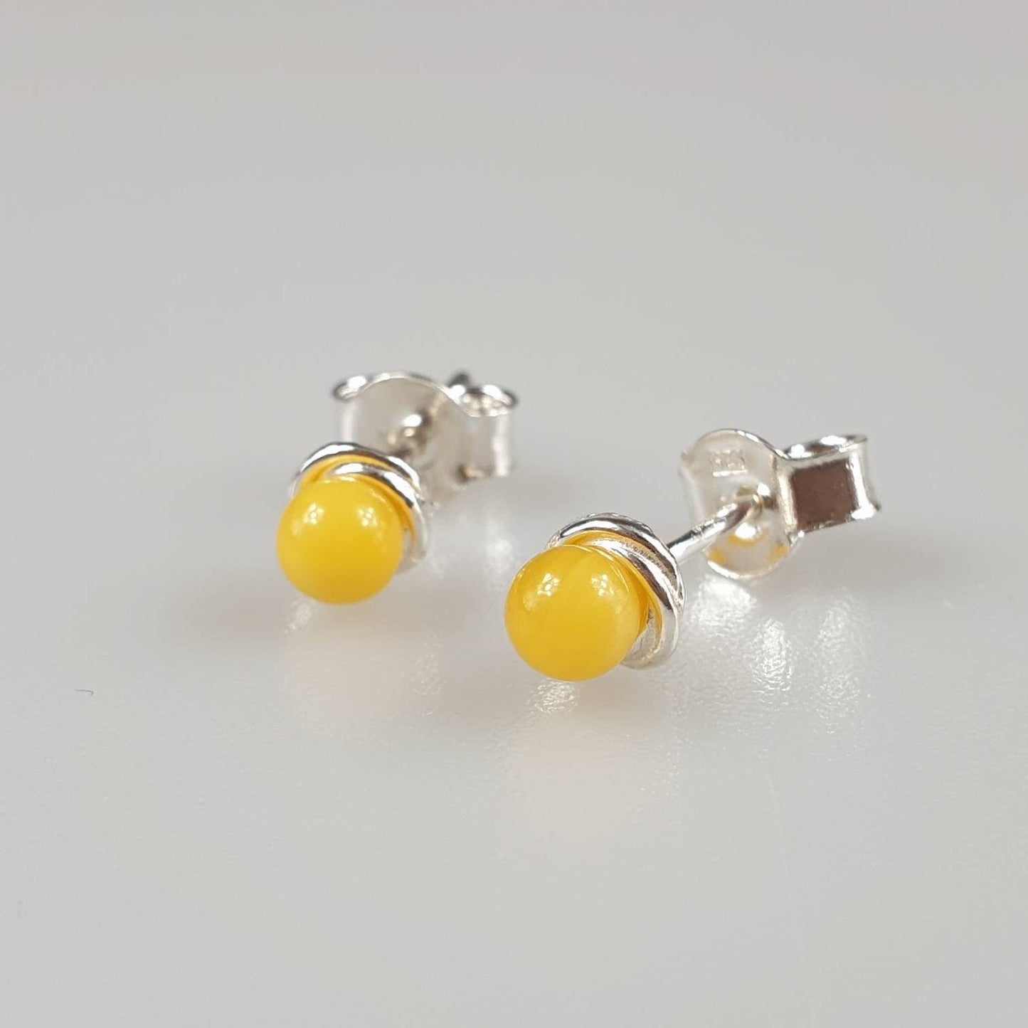 Minimalist amber earrings, small ear stud in the ear, white,