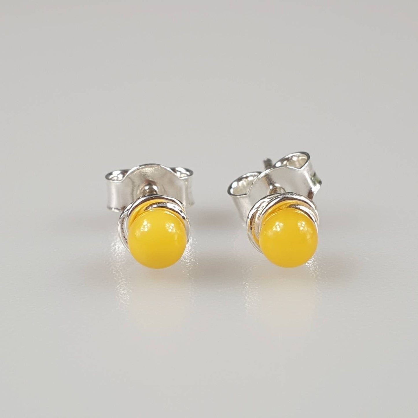 Minimalist amber earrings, small ear stud in the ear, white,