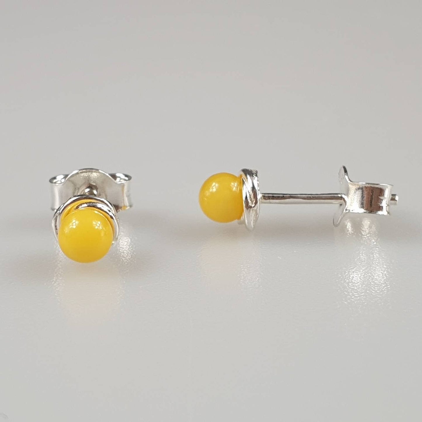 Minimalist amber earrings, small ear stud in the ear, white,